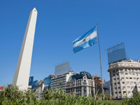 Foto da Capital da Argentina, com a Bandeira do País e um de seus monumentos