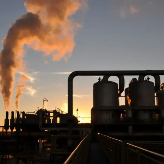 Vista de uma indústria com caldeiras e emissões térmicas, ilustrando ambientes industriais severos que exigem cabos de alta temperatura para suportar calor extremo com segurança e desempenho.