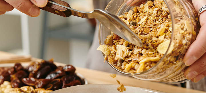 Pessoa servindo granola em uma tigela
