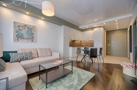 Sala de estar moderna com sofá bege e almofadas azuis