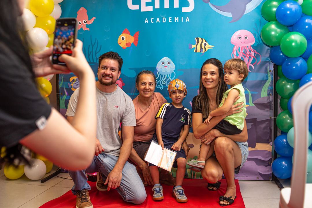 Pais e alunos de natação durante o cerimonial de troca de touca